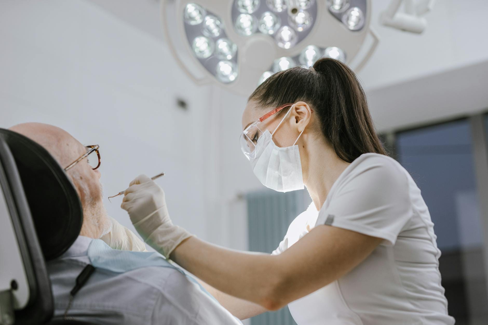 Dentystka leczy pacjenta w nowoczesnym, jasno oświetlonym gabinecie