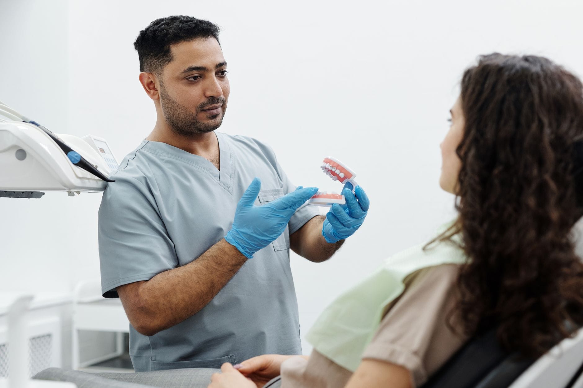 Dentysta pokazuje pacjentowi model szczęki podczas konsultacji ortodontycznej