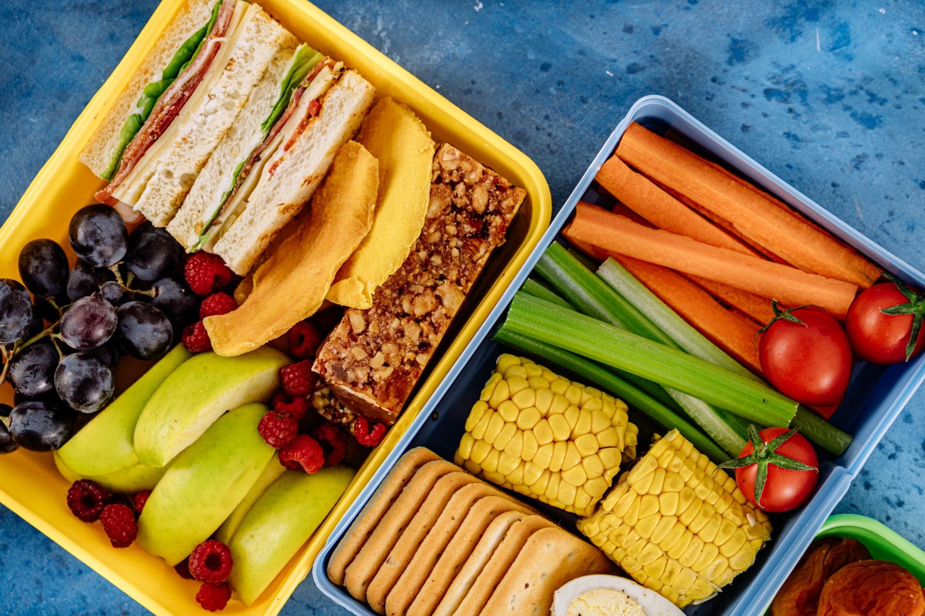 Lunchbox z kanapkami, warzywami i owocami widziany z góry